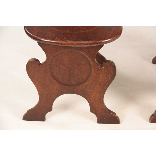 994 - A PAIR OF GEORGE II OAK HALL CHAIRS the slightly bowed shaped solid backs on dished rounded seats an... 