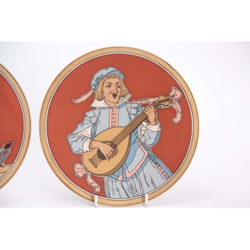 123 - A PAIR OF METTLACH HANGING PLAQUES depicting a pair of figures in drinking and musical pursuits 20cm... 