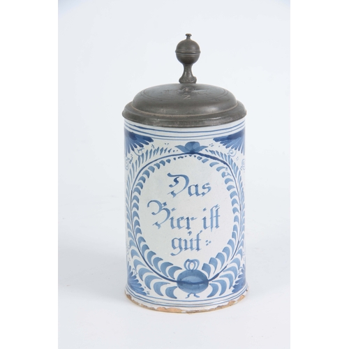 87 - AN 18TH CENTURY GERMAN BLUE AND WHITE PEWTER MOUNTED DELFT TANKARD bearing inscription ‘Das bie ift ... 