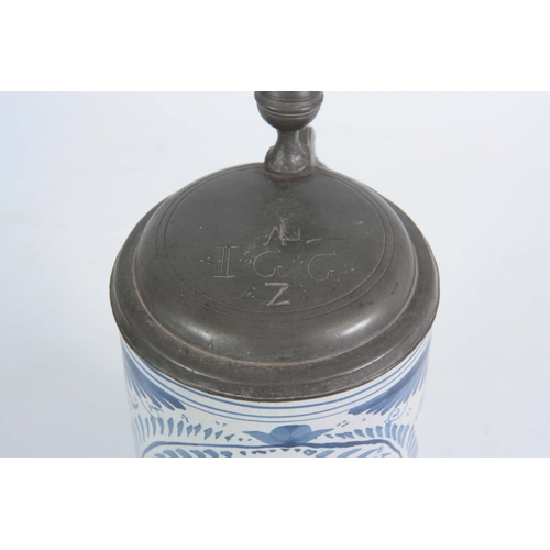 87 - AN 18TH CENTURY GERMAN BLUE AND WHITE PEWTER MOUNTED DELFT TANKARD bearing inscription ‘Das bie ift ... 