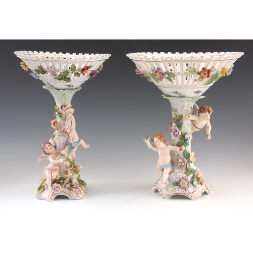 114 - TWO 19TH CENTURY DRESDEN PORCELAIN COMPOTE CENTREPIECES with figural cherub bases and pierced basket... 