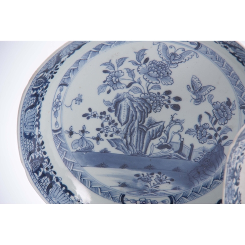 153 - AN 18TH CENTURY CHINESE BLUE AND WHITE SHALLOW DISH with fenced garden scene and butterfly centre en... 