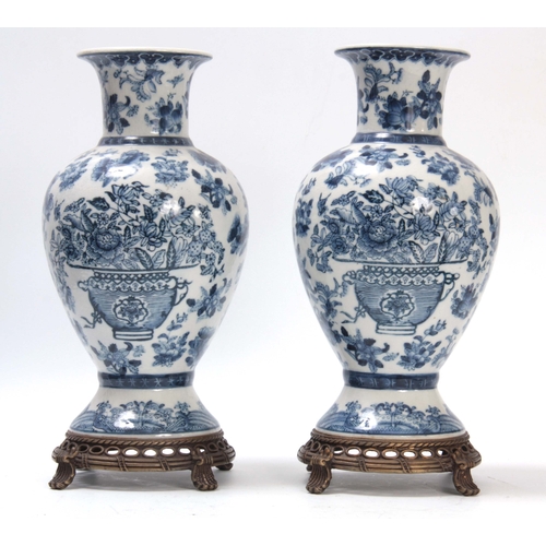 157 - A PAIR OF ORIENTAL BLUE AND WHITE BALUSTER VASES WITH PIERCED METAL BASES AND SCROLL FEET allover de... 