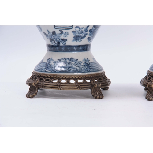 157 - A PAIR OF ORIENTAL BLUE AND WHITE BALUSTER VASES WITH PIERCED METAL BASES AND SCROLL FEET allover de... 