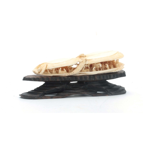 184 - A CHINESE CANTON IVORY SCULPTURE modelled as two mussel shells slightly opened revealing an intricat... 