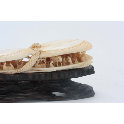 184 - A CHINESE CANTON IVORY SCULPTURE modelled as two mussel shells slightly opened revealing an intricat... 