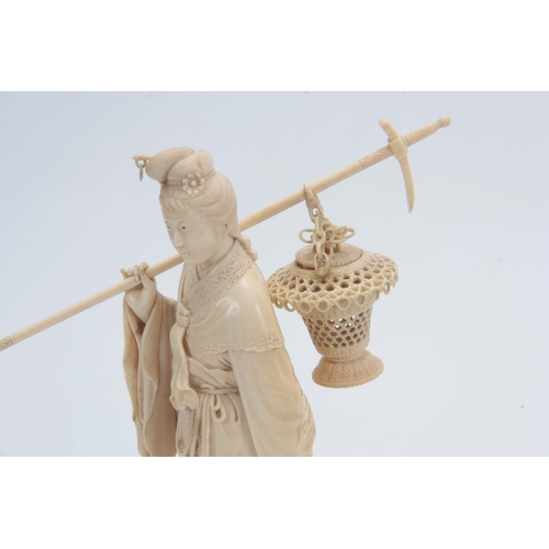 193 - A 19TH CENTURY CHINESE CARVED IVORY FIGURE OF A STANDING YOUNG LADY in elaborate costume carrying a ... 