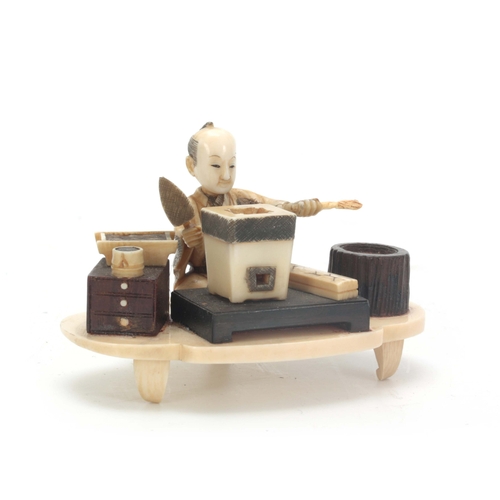 199 - A JAPANESE MEIJI PERIOD IVORY AND STAINED IVORY OKIMONO the seated figure modelled as a brickmaker w... 