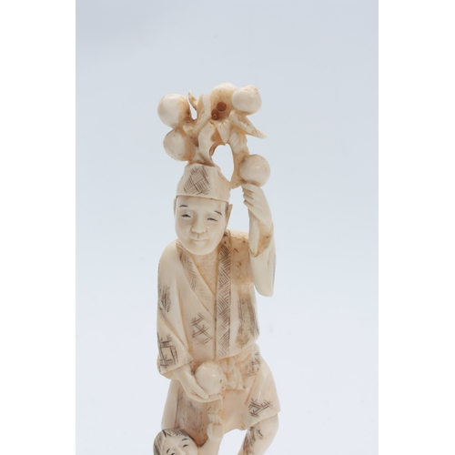 201 - A JAPANESE MEIJI PERIOD IVORY OKIMONO modelled as a father and child carrying fruit 21cm high, signe... 