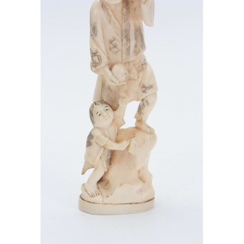 201 - A JAPANESE MEIJI PERIOD IVORY OKIMONO modelled as a father and child carrying fruit 21cm high, signe... 