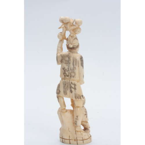 201 - A JAPANESE MEIJI PERIOD IVORY OKIMONO modelled as a father and child carrying fruit 21cm high, signe... 