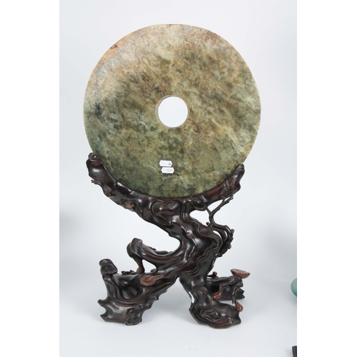 213 - A LARGE 18th/19th CENTURY CHINESE JADE PI ON HARDWOOD STAND the large circular spinach green jade wi... 