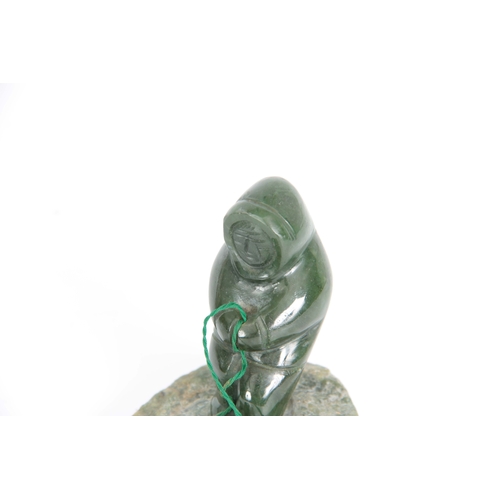 215 - A 20TH CENTURY JADE INDUIT SCULTURE depicting a man fishing 9cm wide 8cm high.