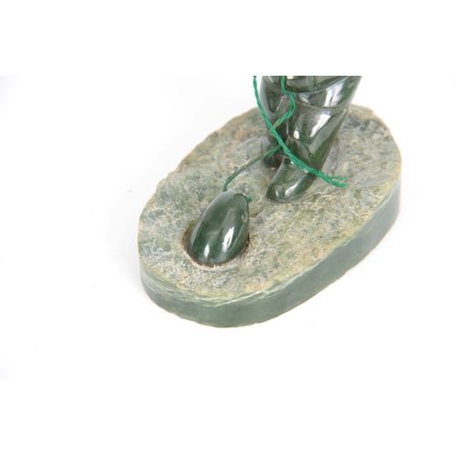 215 - A 20TH CENTURY JADE INDUIT SCULTURE depicting a man fishing 9cm wide 8cm high.