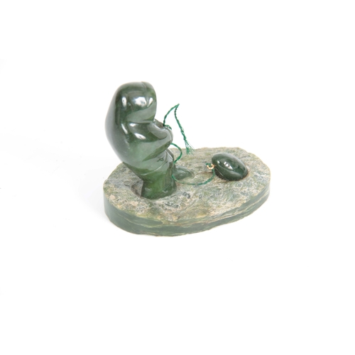 215 - A 20TH CENTURY JADE INDUIT SCULTURE depicting a man fishing 9cm wide 8cm high.