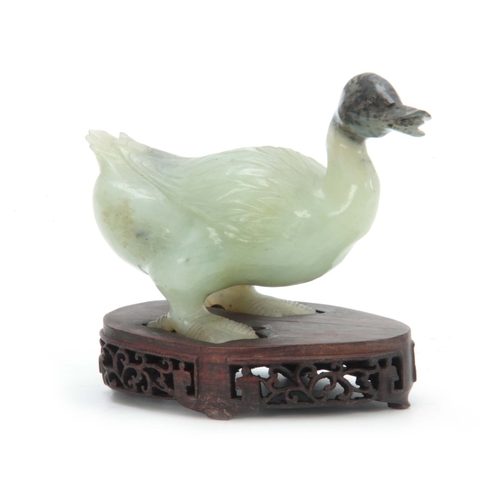 216 - A CHINESE CARVED SCULPTURE OF A DUCK mounted on a pierced hardwood base 14cm wide 11cm high.