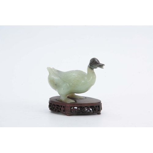 216 - A CHINESE CARVED SCULPTURE OF A DUCK mounted on a pierced hardwood base 14cm wide 11cm high.