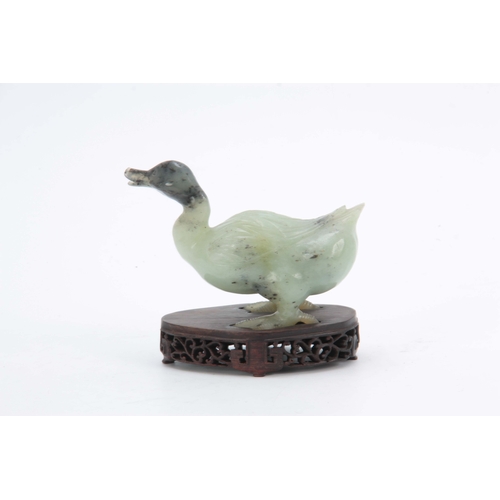 216 - A CHINESE CARVED SCULPTURE OF A DUCK mounted on a pierced hardwood base 14cm wide 11cm high.