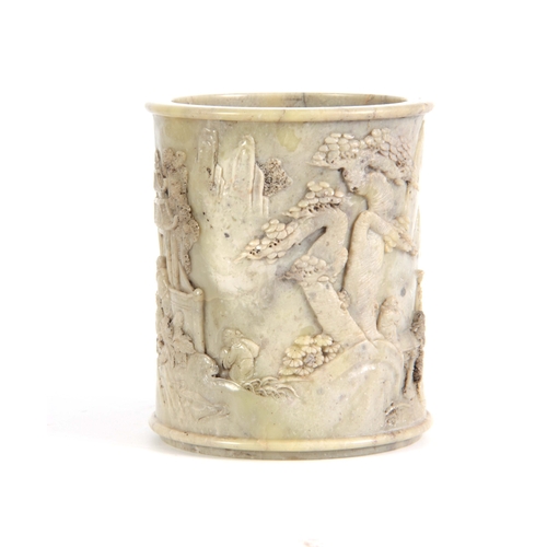 218 - A 19TH CENTURY CHINESE  PALE GREEN SOAPSTONE BRUSH POT the cylindrical body carved in high relief wi... 