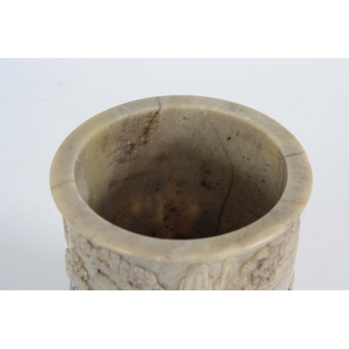 218 - A 19TH CENTURY CHINESE  PALE GREEN SOAPSTONE BRUSH POT the cylindrical body carved in high relief wi... 