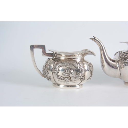 224 - A 19TH CENTURY CHINESE THREE-PIECE SILVER TEA SERVICE of oblate panelled form with folded rims, each... 