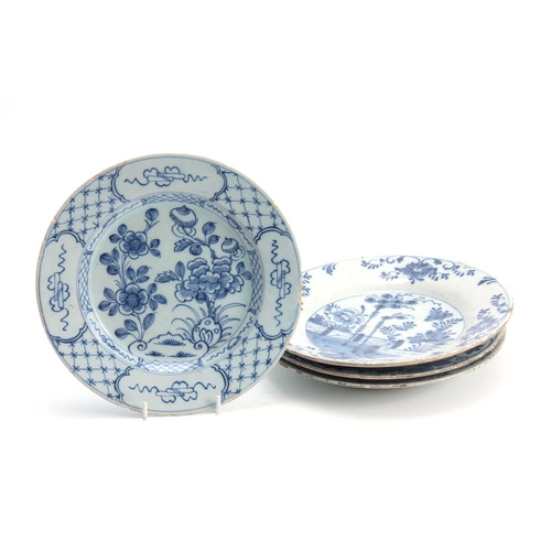 83 - FOUR 18TH CENTURY DELFT BLUE AND WHITE PLATES decorated with floral designs 23cm diameter.