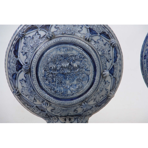 89 - A PAIR OF 19TH CENTURY GERMAN WESTERWALD SALT GLAZED EWERS the large rounded bodies with relief moul... 