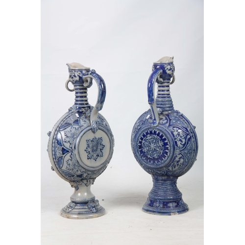 89 - A PAIR OF 19TH CENTURY GERMAN WESTERWALD SALT GLAZED EWERS the large rounded bodies with relief moul... 