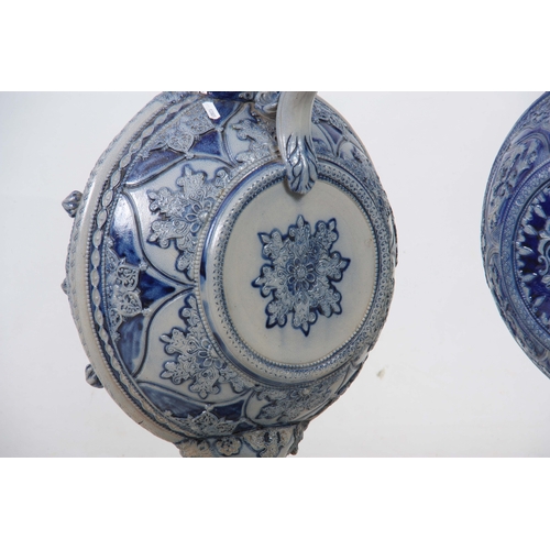 89 - A PAIR OF 19TH CENTURY GERMAN WESTERWALD SALT GLAZED EWERS the large rounded bodies with relief moul... 