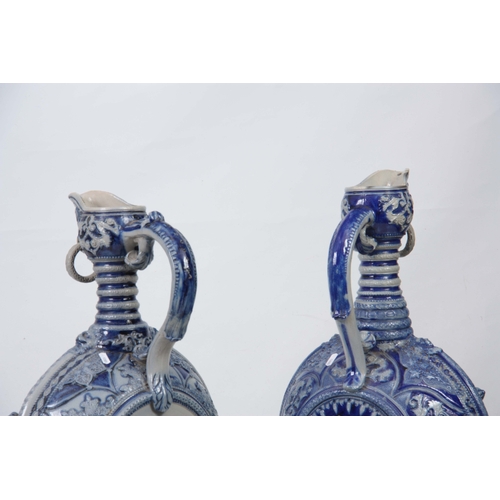 89 - A PAIR OF 19TH CENTURY GERMAN WESTERWALD SALT GLAZED EWERS the large rounded bodies with relief moul... 