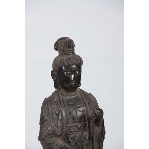 241 - A 19TH CENTURY CHINESE BRONZE FIGURE OF GUANYIN mounted on a naturalistic base 96cm high.