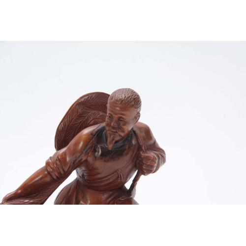 274 - A LATE 19th CENTURY CHINESE HARDWOOD CARVED FIGURE modeled as a fisherman pulling in his catch, the ... 