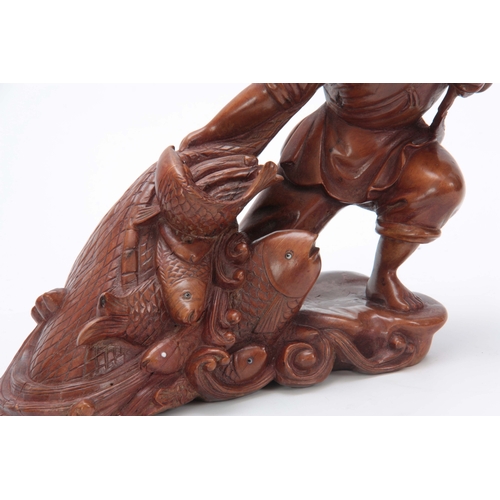 274 - A LATE 19th CENTURY CHINESE HARDWOOD CARVED FIGURE modeled as a fisherman pulling in his catch, the ... 