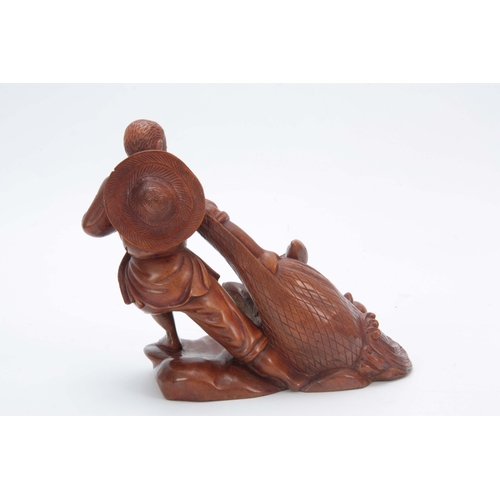 274 - A LATE 19th CENTURY CHINESE HARDWOOD CARVED FIGURE modeled as a fisherman pulling in his catch, the ... 