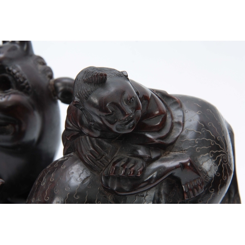 276 - A LATE 19th CENTURY CHINESE HARDWOOD FIGURE RIDING A FOO DOG with glass eyes and bone teeth standing... 