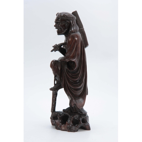 277 - A 19TH CENTURY CHINESE HARDWOOD STANDING FIGURE with finely detailed decoration 43cm high