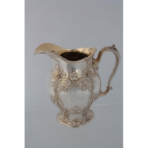 371 - AN AMERICAN ART NOUVEAU SILVER GILT WATER JUG having embossed foliate scrollwork decoration 23cm hig... 