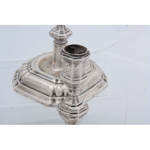 382 - A SET OF FOUR CONTINENTAL CAST SILVER CANDLE STICKS having moulded square bases, octagonal stems, ap... 