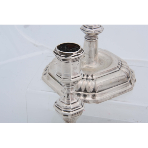 382 - A SET OF FOUR CONTINENTAL CAST SILVER CANDLE STICKS having moulded square bases, octagonal stems, ap... 