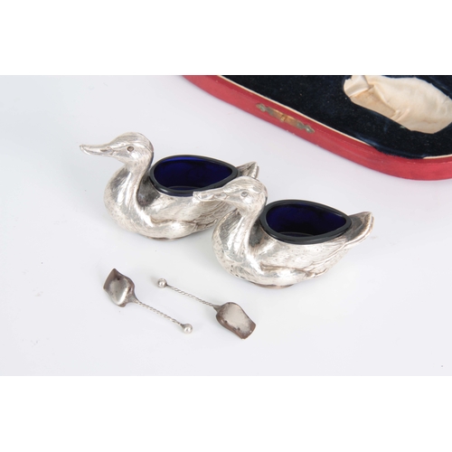 383 - A CASED PAIR OF FIGURAL SILVER SALTS MODELLED AS DUCKS WITH SHOVEL SHAPED SALT SPOONS hallmarked for... 