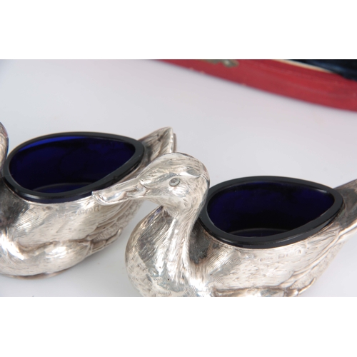 383 - A CASED PAIR OF FIGURAL SILVER SALTS MODELLED AS DUCKS WITH SHOVEL SHAPED SALT SPOONS hallmarked for... 