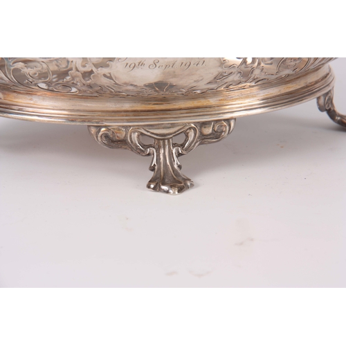 393 - A GEORGE V SILVER CENTER BASKET of pierced scrollwork design supported on four fluted feet 26.5cm wi... 