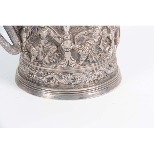 395 - A LATE 19th / EARLY 20th CENTURY INDIAN SILVER TANKARD having high relief decoration of female dance... 