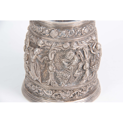 395 - A LATE 19th / EARLY 20th CENTURY INDIAN SILVER TANKARD having high relief decoration of female dance... 