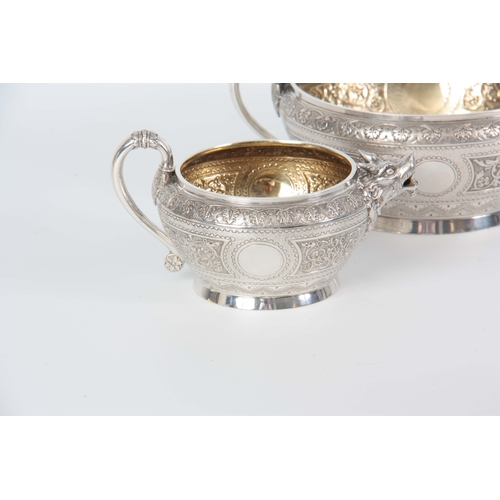 401 - A VICTORIAN SILVER AND GILT CREAM JUG AND SUGAR BOWL  having relief scroll-work panels and fine engr... 