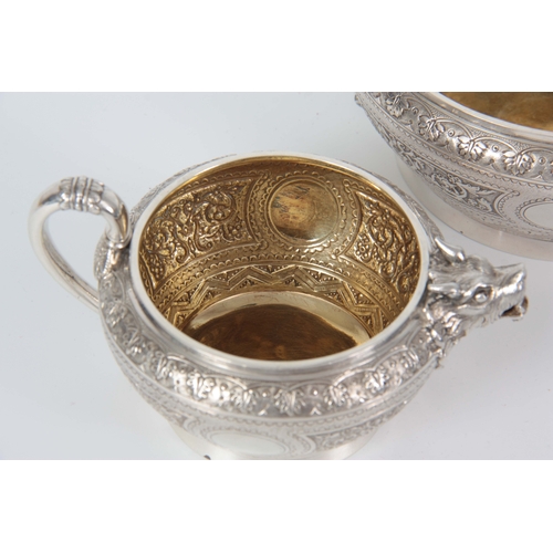 401 - A VICTORIAN SILVER AND GILT CREAM JUG AND SUGAR BOWL  having relief scroll-work panels and fine engr... 