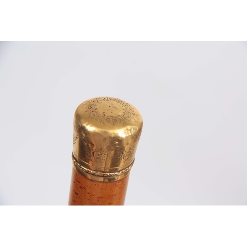 447 - AN EARLY 19th CENTURY 18CT GOLD AND MALACCA WALKING CANE having a floral engraved pommel with eagle ... 