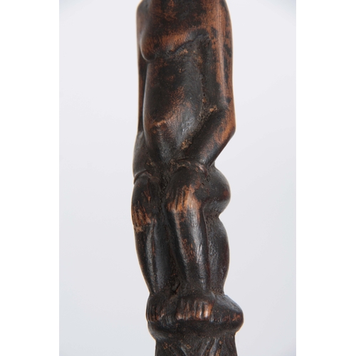 449 - AN AFRICAN CARVED EBONISED WALKING CANE the handle modelled as a seated figure 96cm overall