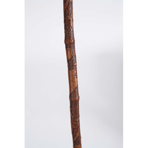 450 - A 19th CENTURY JAPANESE BAMBOO WALKING CANE having a root handle, the stick carved all over with var... 