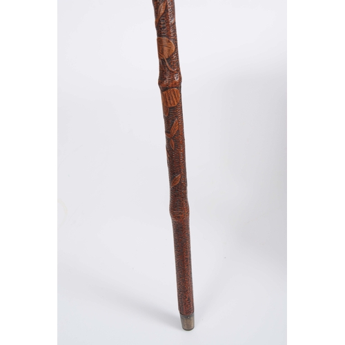 450 - A 19th CENTURY JAPANESE BAMBOO WALKING CANE having a root handle, the stick carved all over with var... 